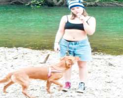 She is accompanied by a big dog in her home.